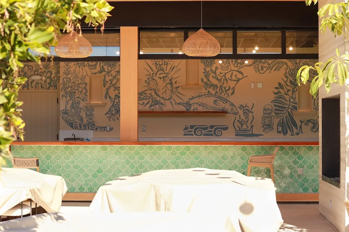 Stylish restaurant interior with artistic mural and green tile accents