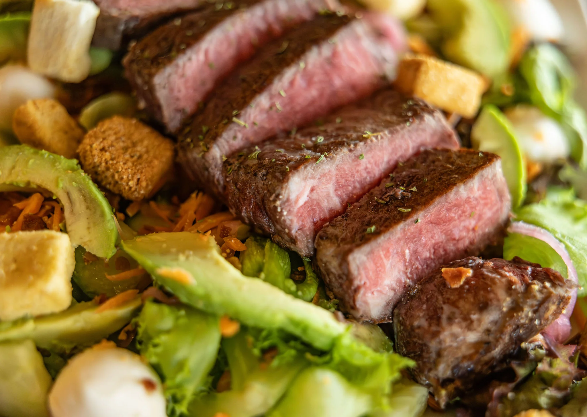Grilled steak salad with fresh greens and toppings