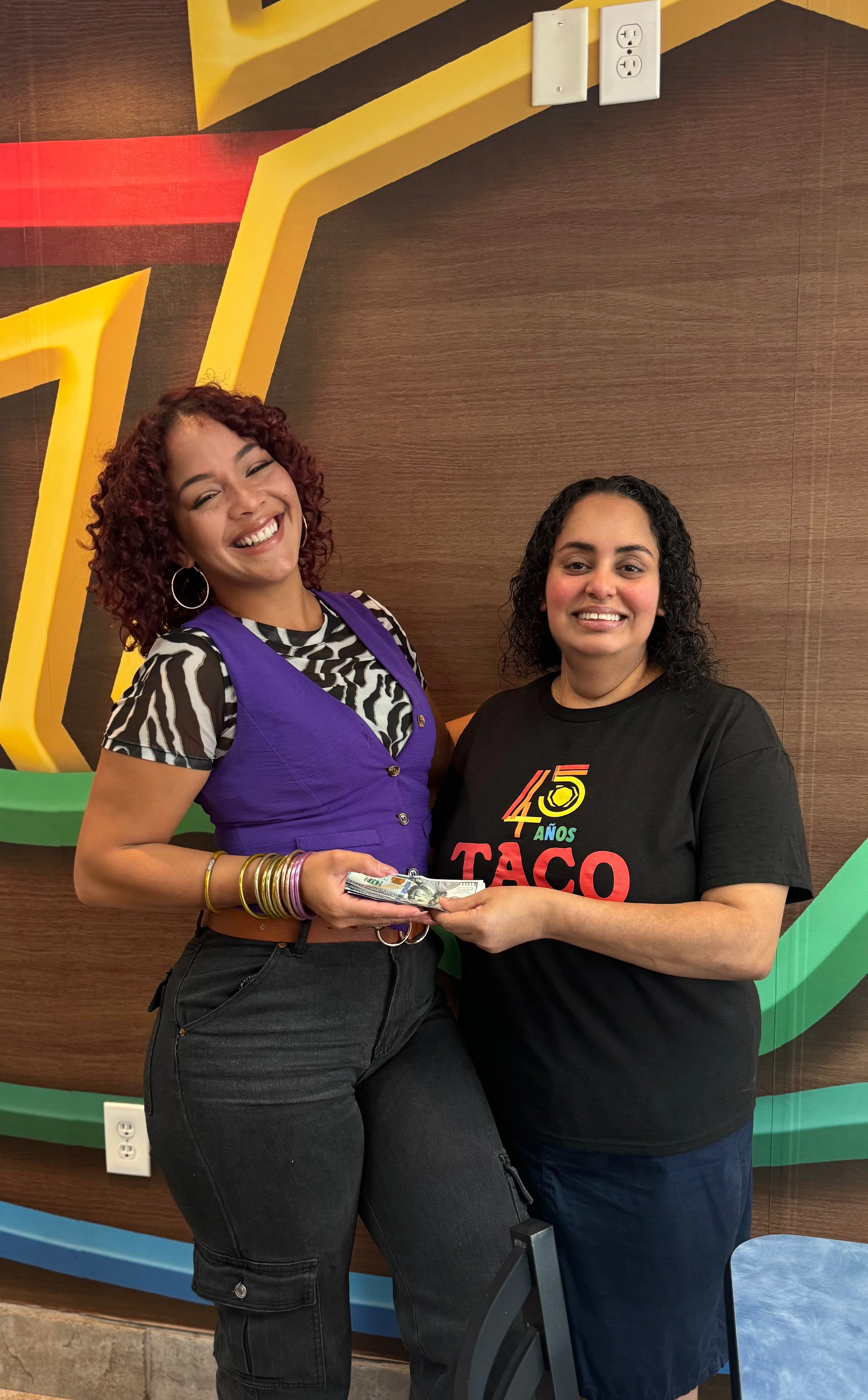 Two women celebrating at a taco restaurant