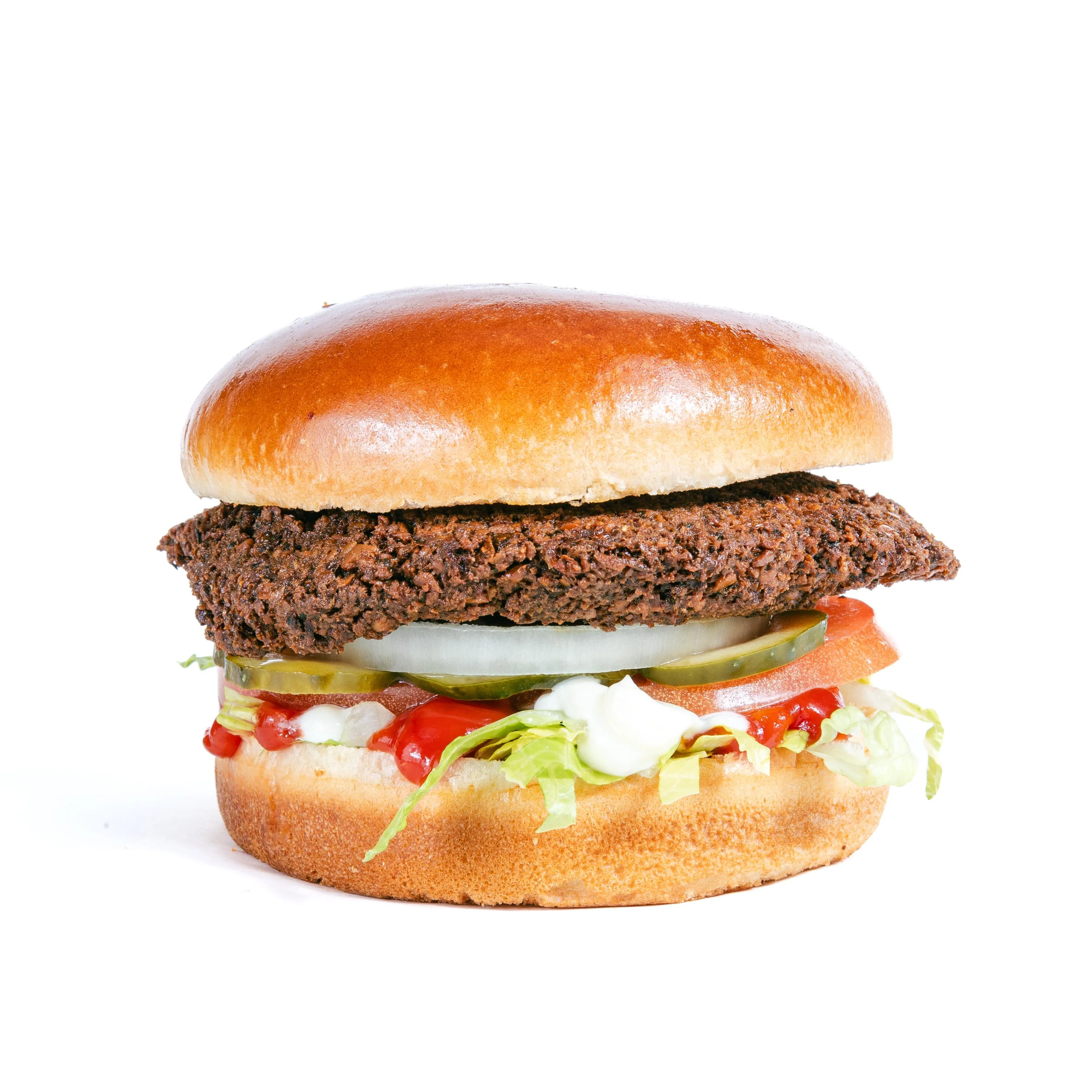 A burger featuring a crispy patty, with lettuce, tomato, pickles, and sauces sandwiched between a toasted bun.