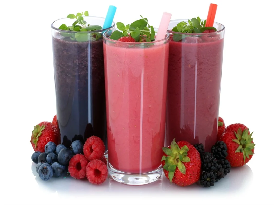 Colorful berry smoothies in tall glasses with fresh mint