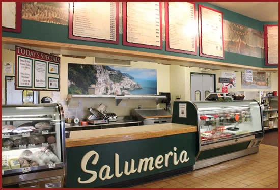 Interior of a salumeria with deli counters and menu boards