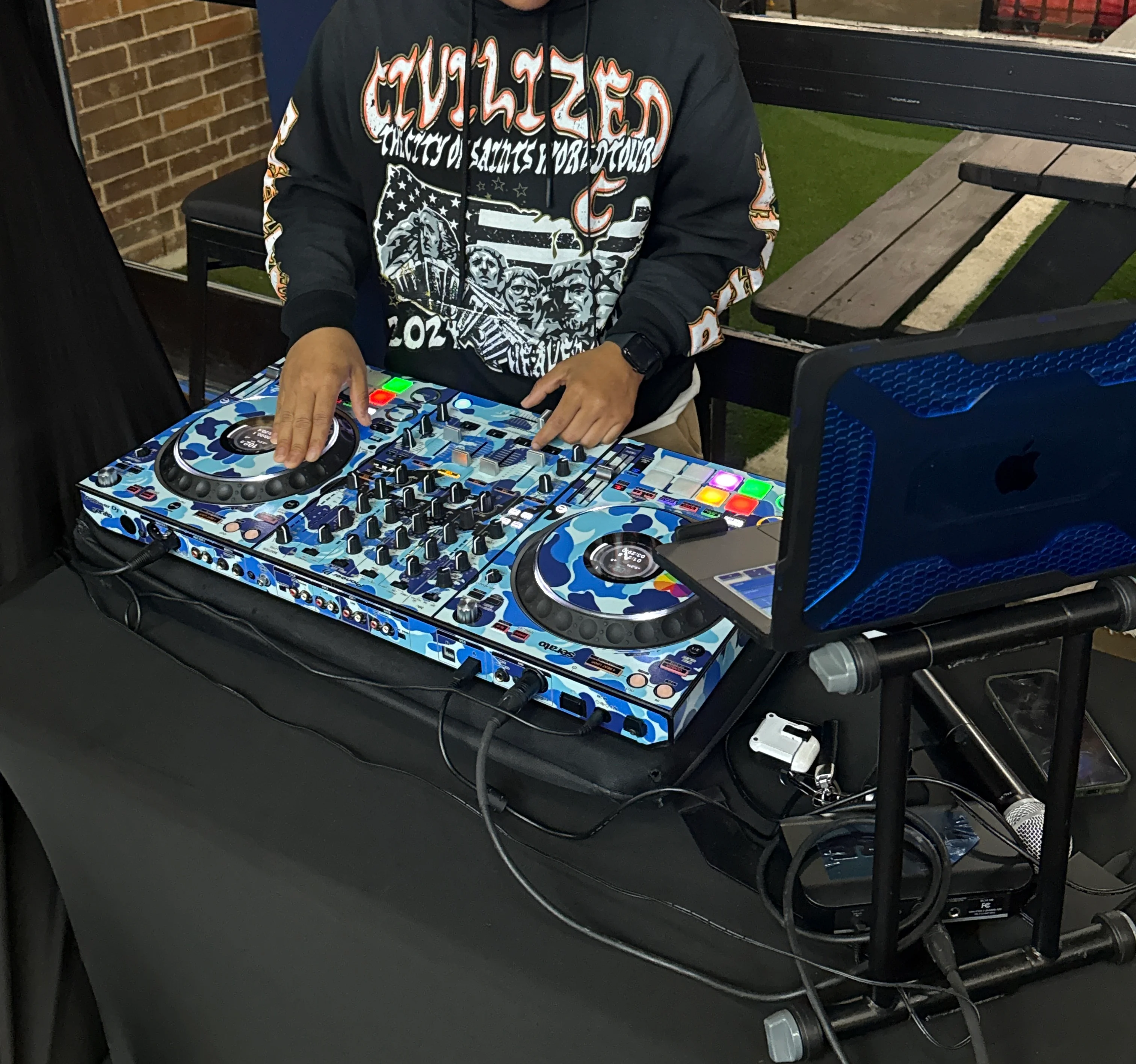 DJ performing at a vibrant event with colorful equipment