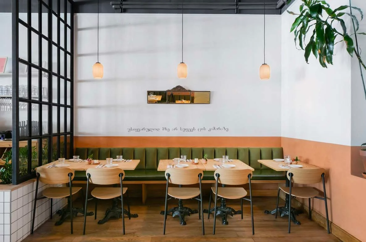 Cozy restaurant interior with green seating and warm lighting