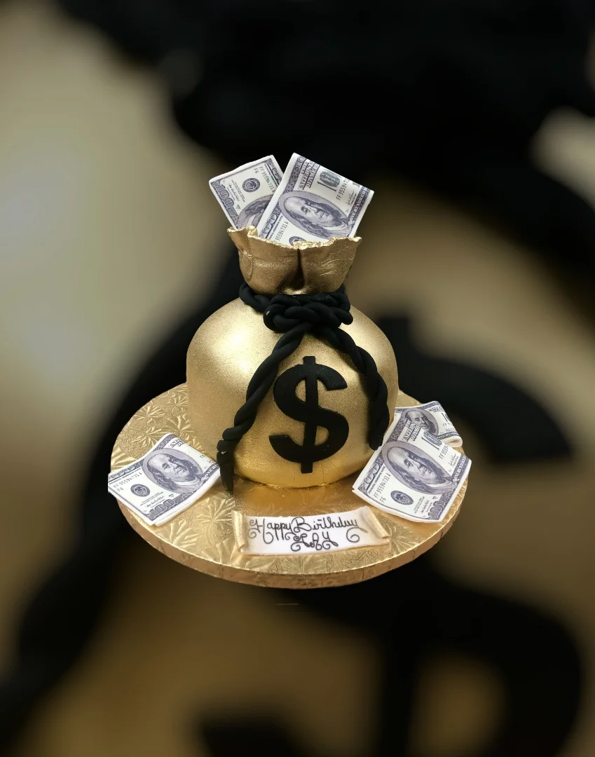 Gold money bag cake with dollar bills for a birthday celebration