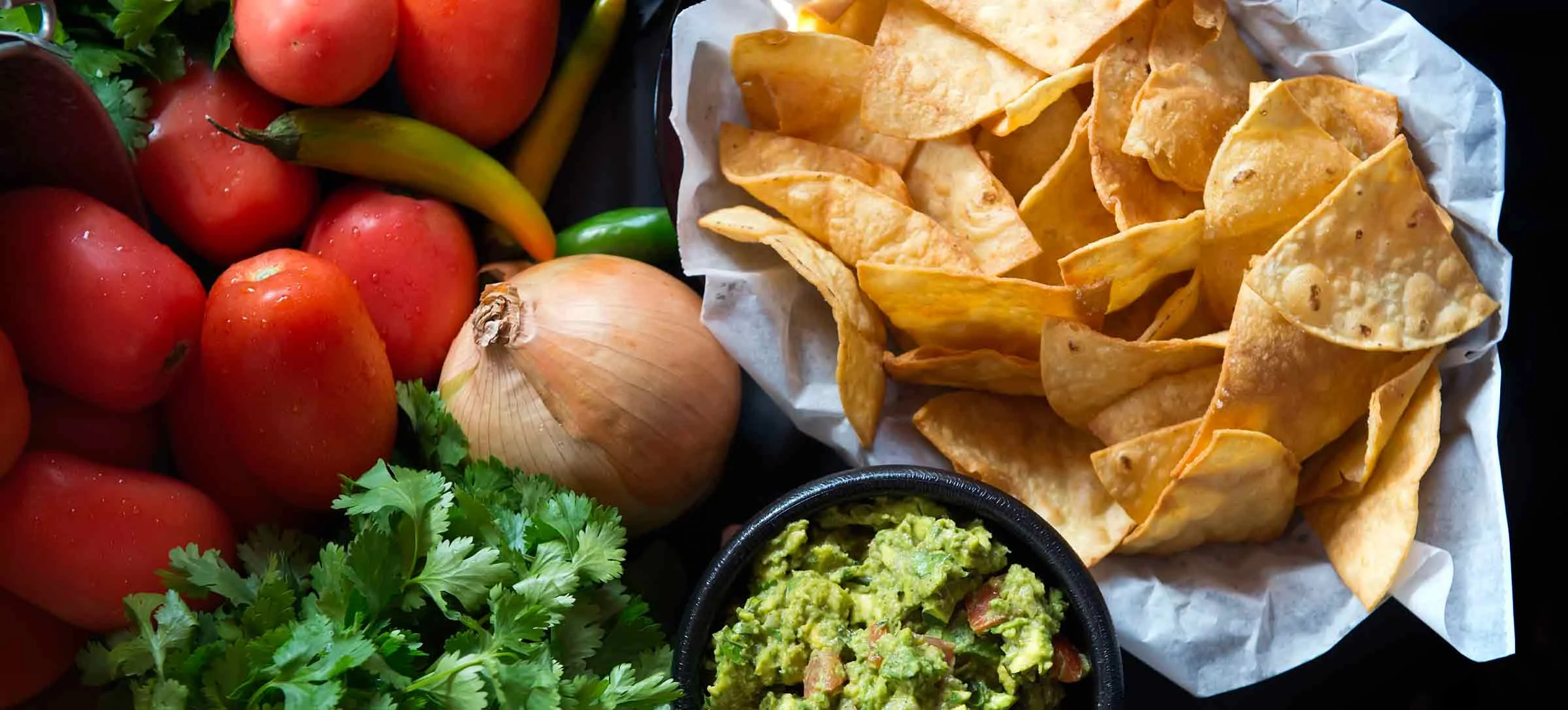 Fresh guacamole with tortilla chips and vibrant vegetables
