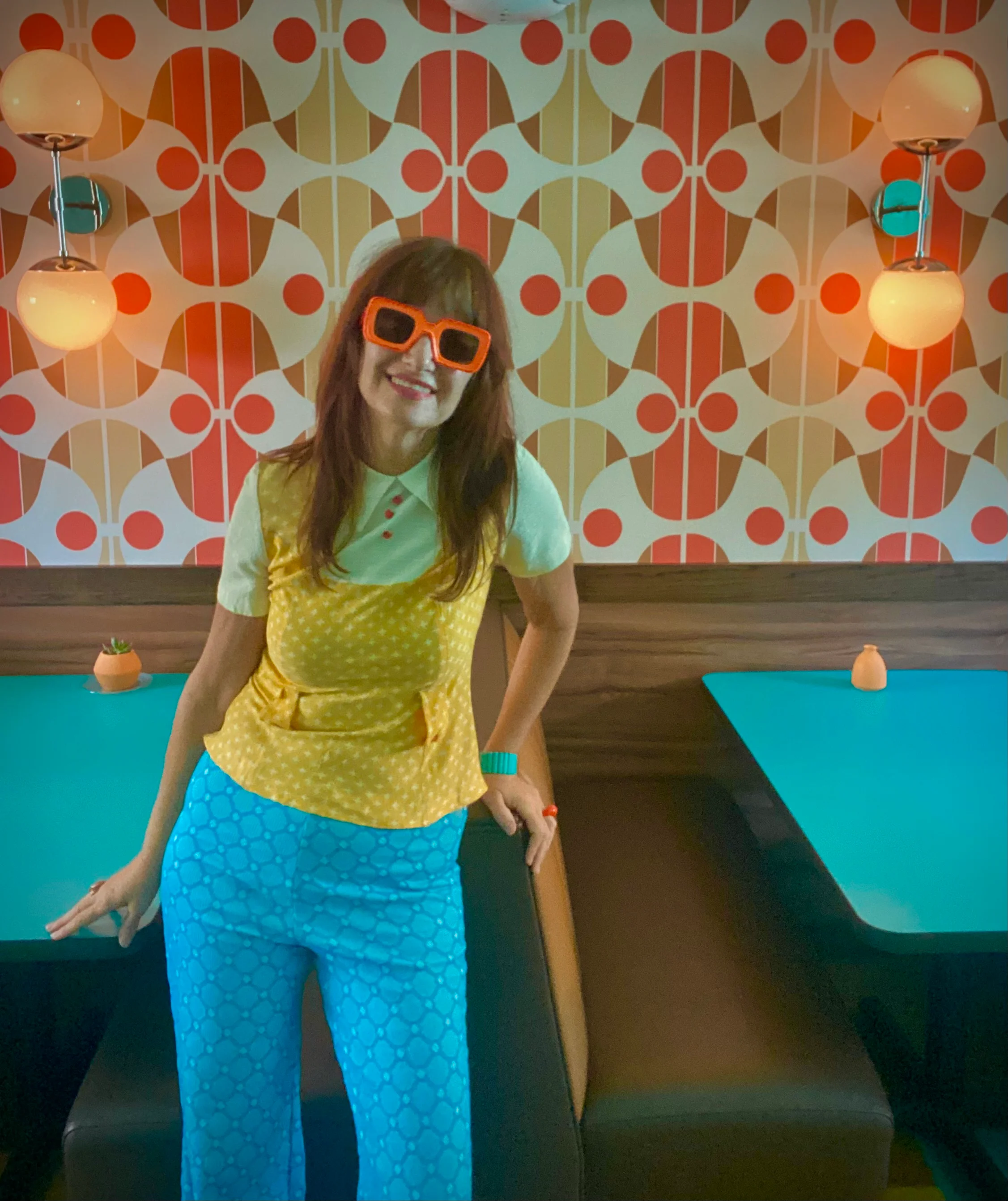 Retro restaurant interior with colorful geometric wallpaper and seated diner