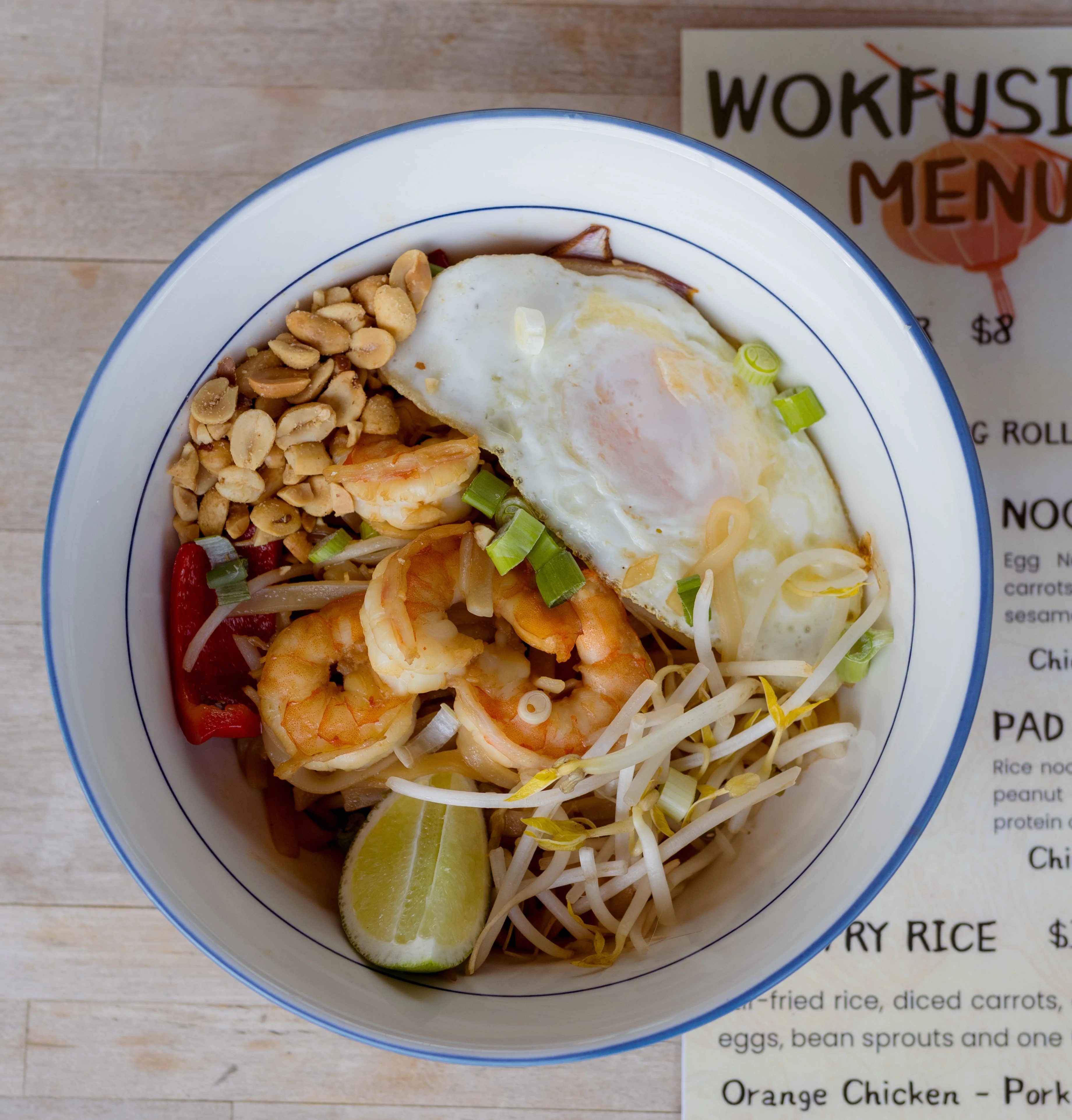 Shrimp pad thai with egg and peanuts in a bowl