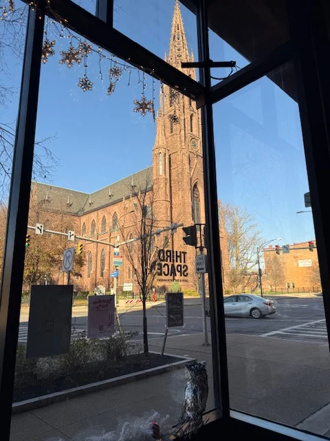 View of a historic church from a cozy restaurant window