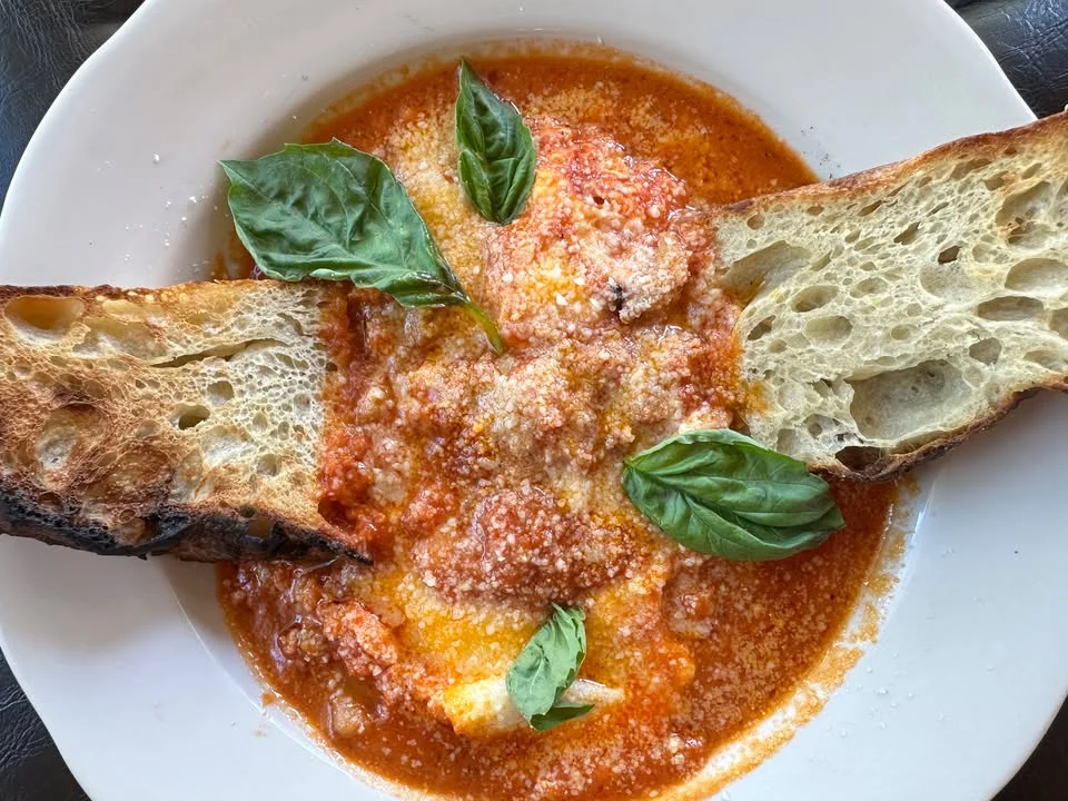 Baked eggs in marinara sauce with crusty bread