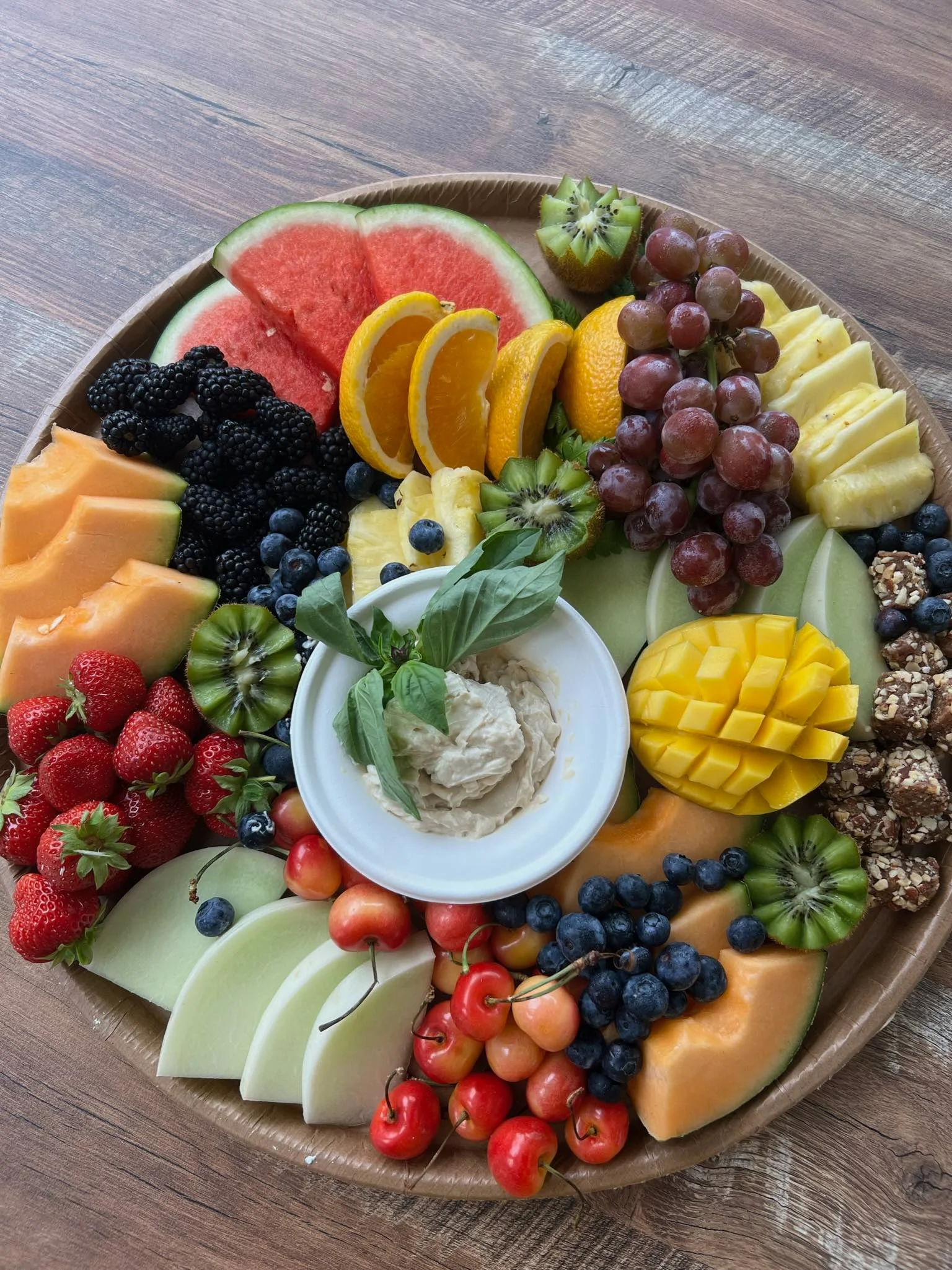 Colorful fruit platter with fresh seasonal fruits and dip