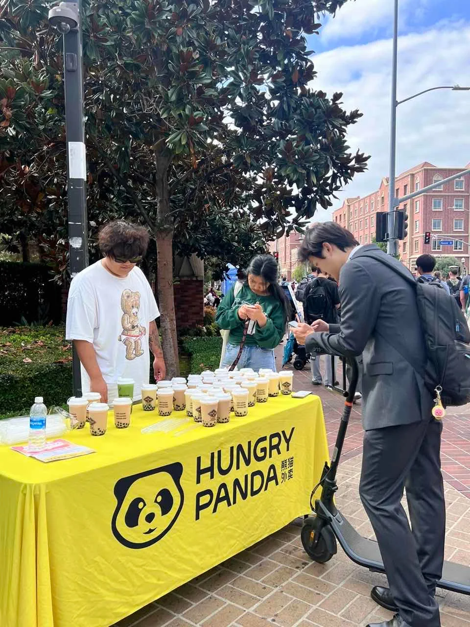 Boba tea stand with various drinks at a lively outdoor event