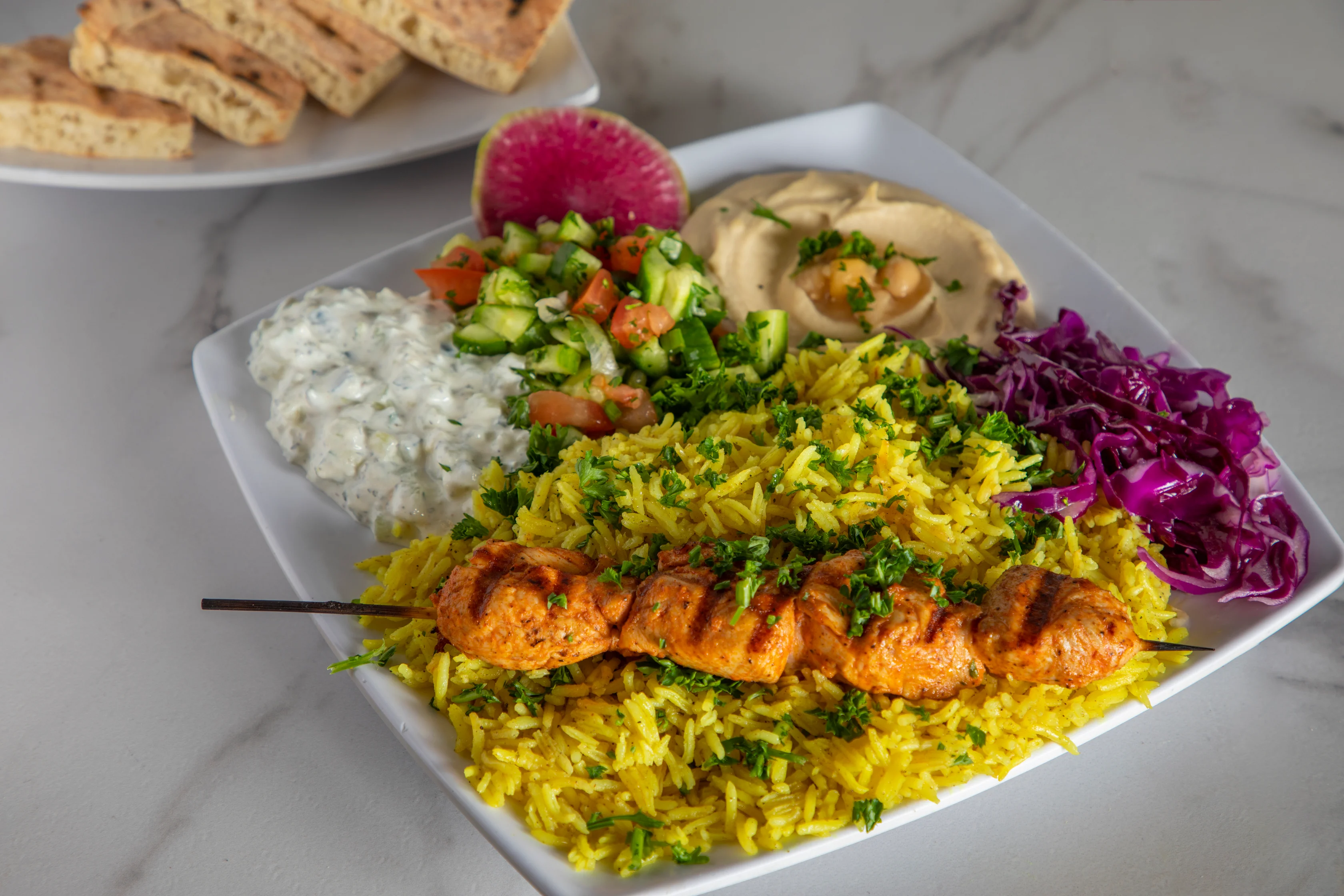 Middle Eastern chicken kebab platter with rice and dips