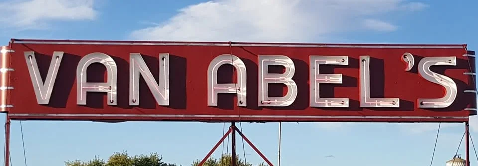 Van Abel's restaurant sign against a blue sky