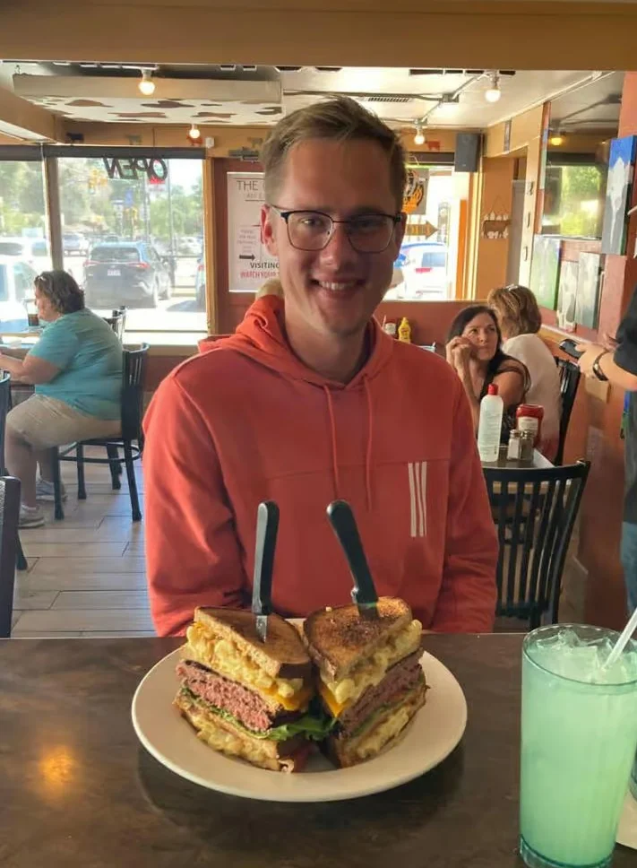 Giant grilled cheese sandwich stack in a casual diner