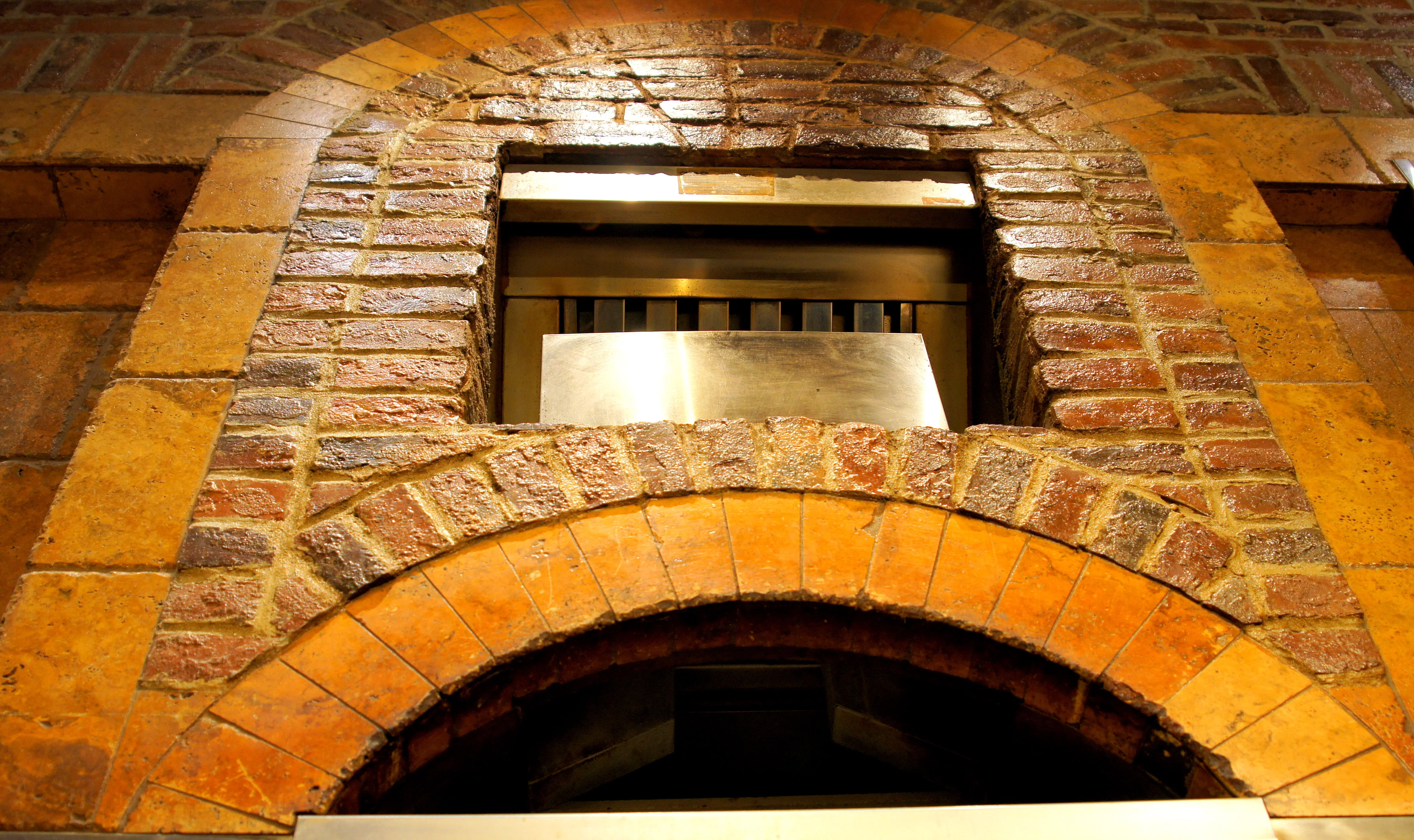 Exposed brick oven opening in a rustic restaurant