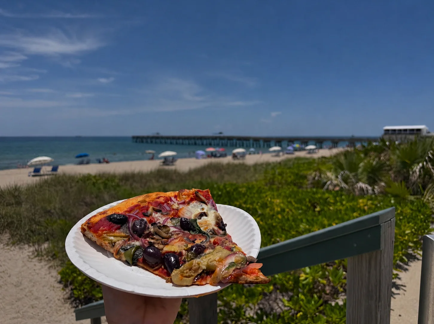 Slice of Mediterranean pizza by the beach