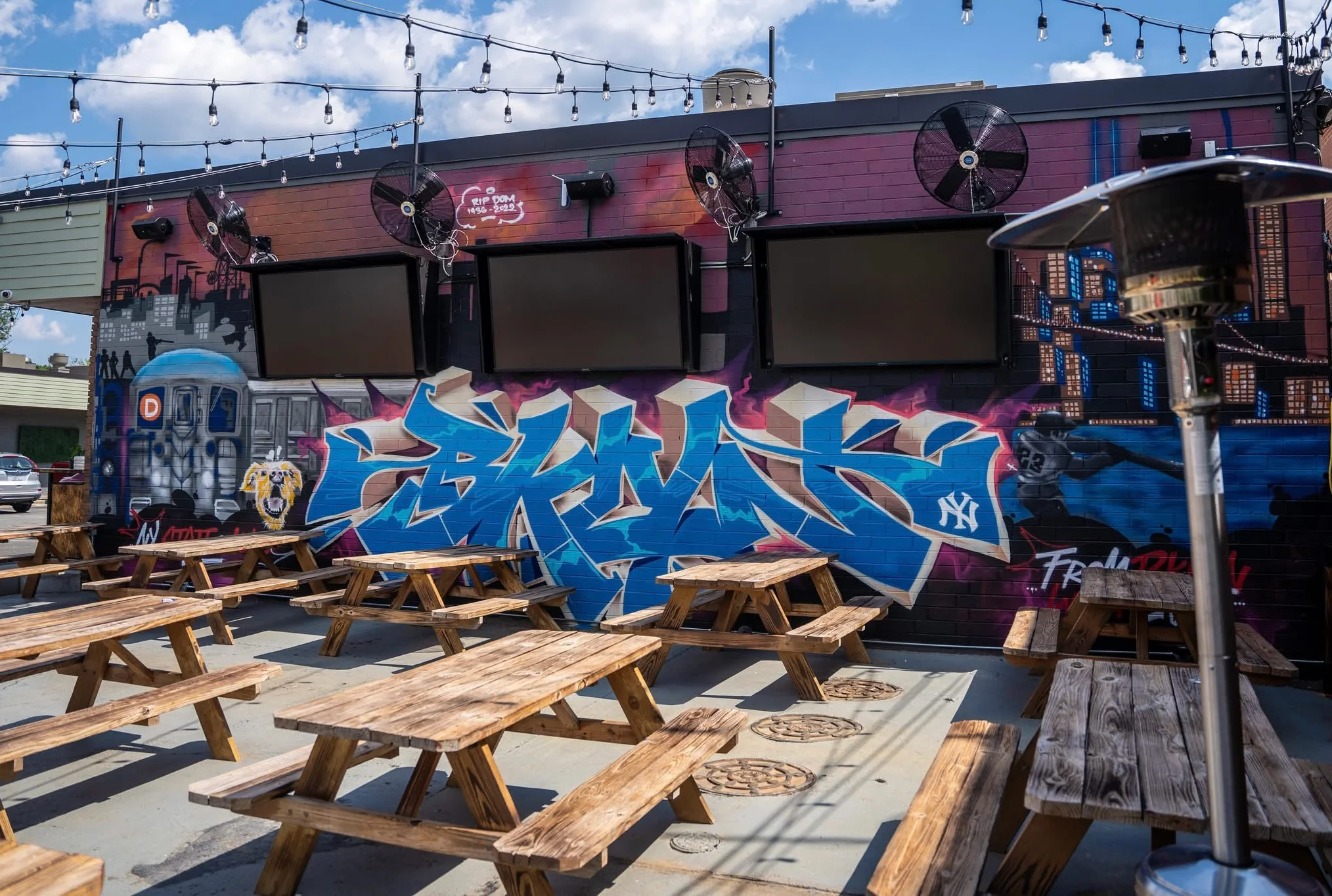 Outdoor patio with colorful graffiti wall and seating area.