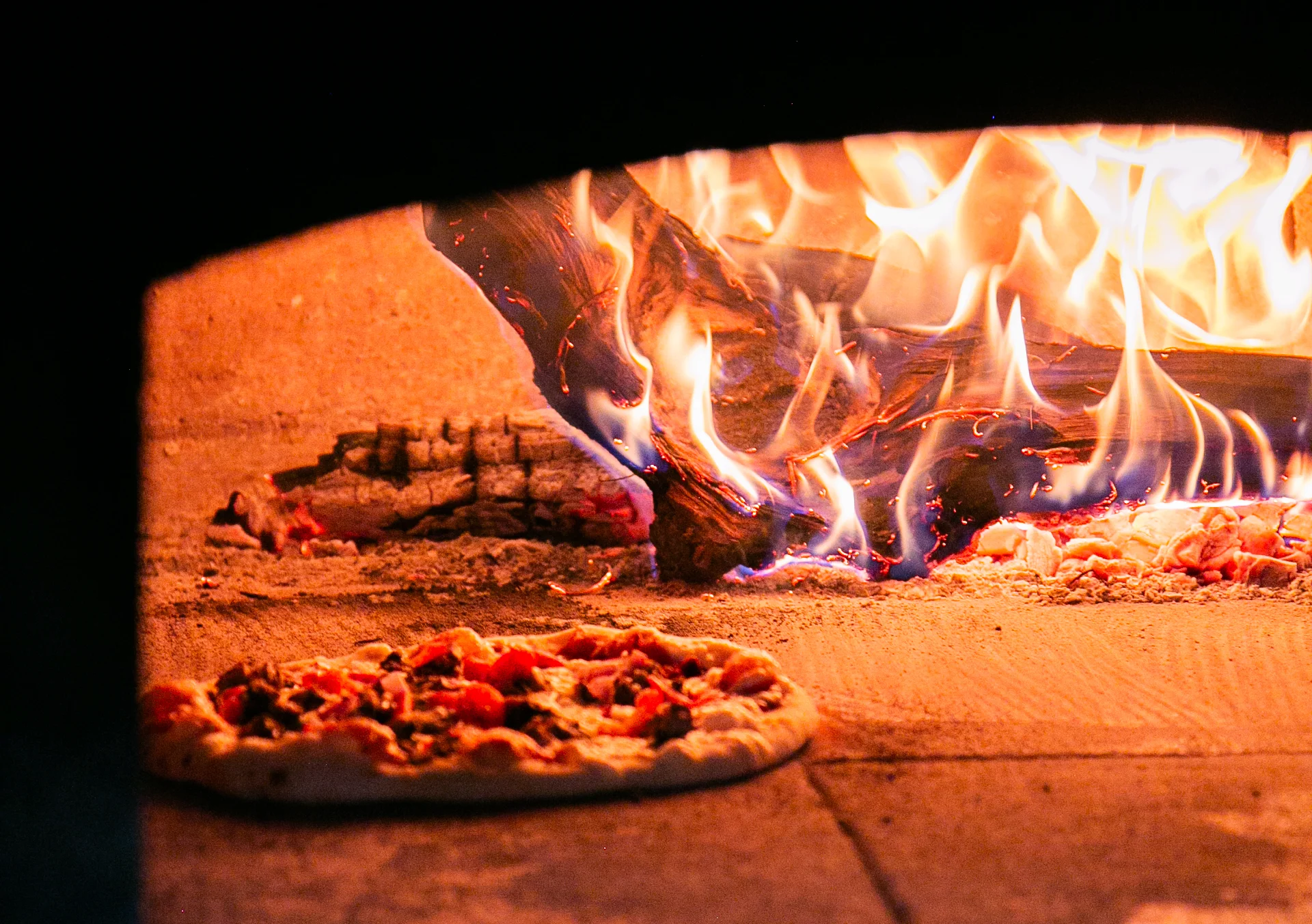 Pizza chief preparing wood fired pizza