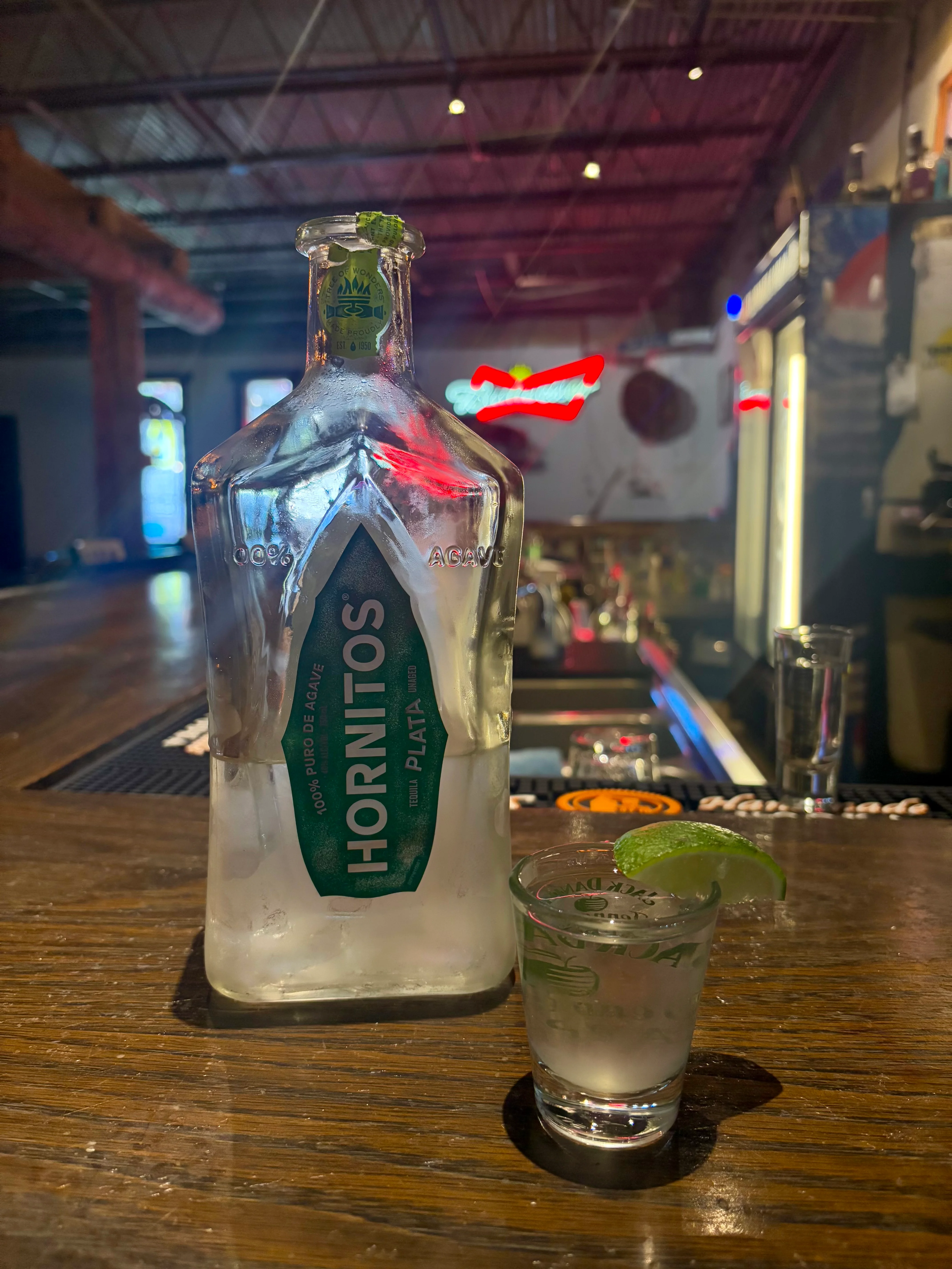 Bottle of Hornitos tequila with a shot glass and lime wedge