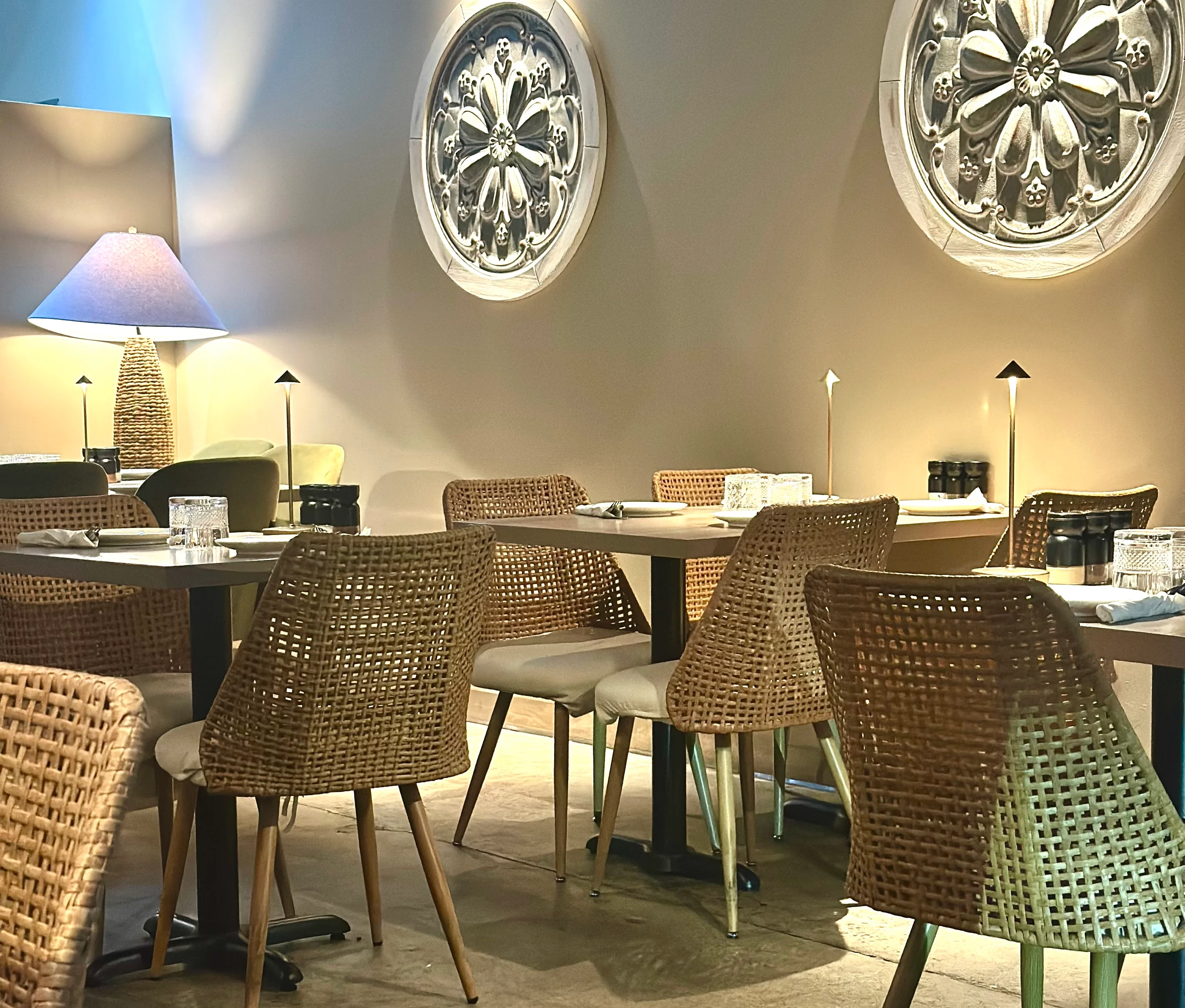 Stylish restaurant interior with woven chairs and decorative wall art