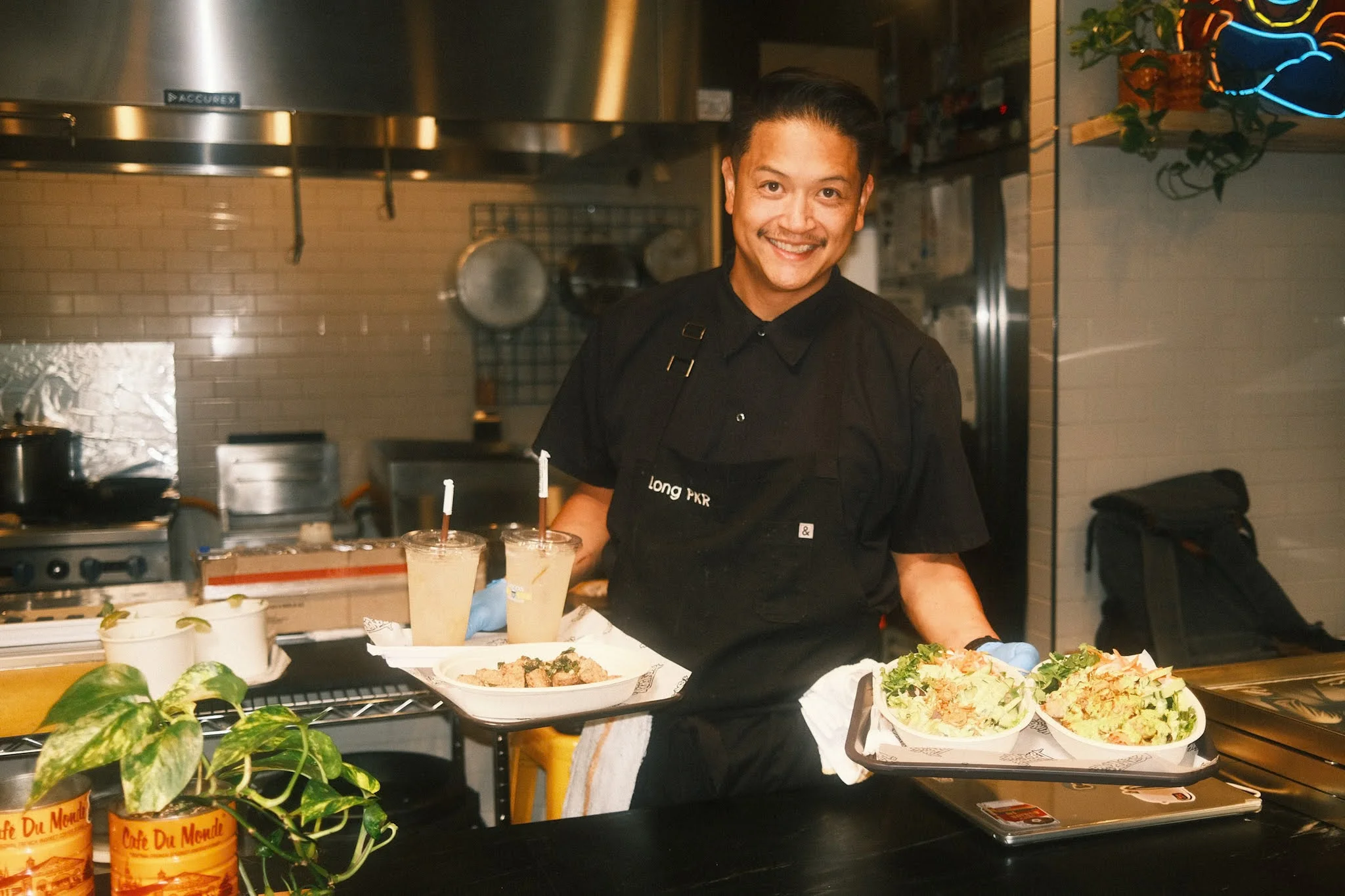 Chef presenting Vietnamese banh xeo with fresh herbs and drinks