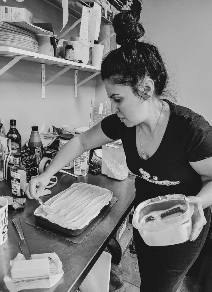 Baker decorating a dessert in a cozy kitchen