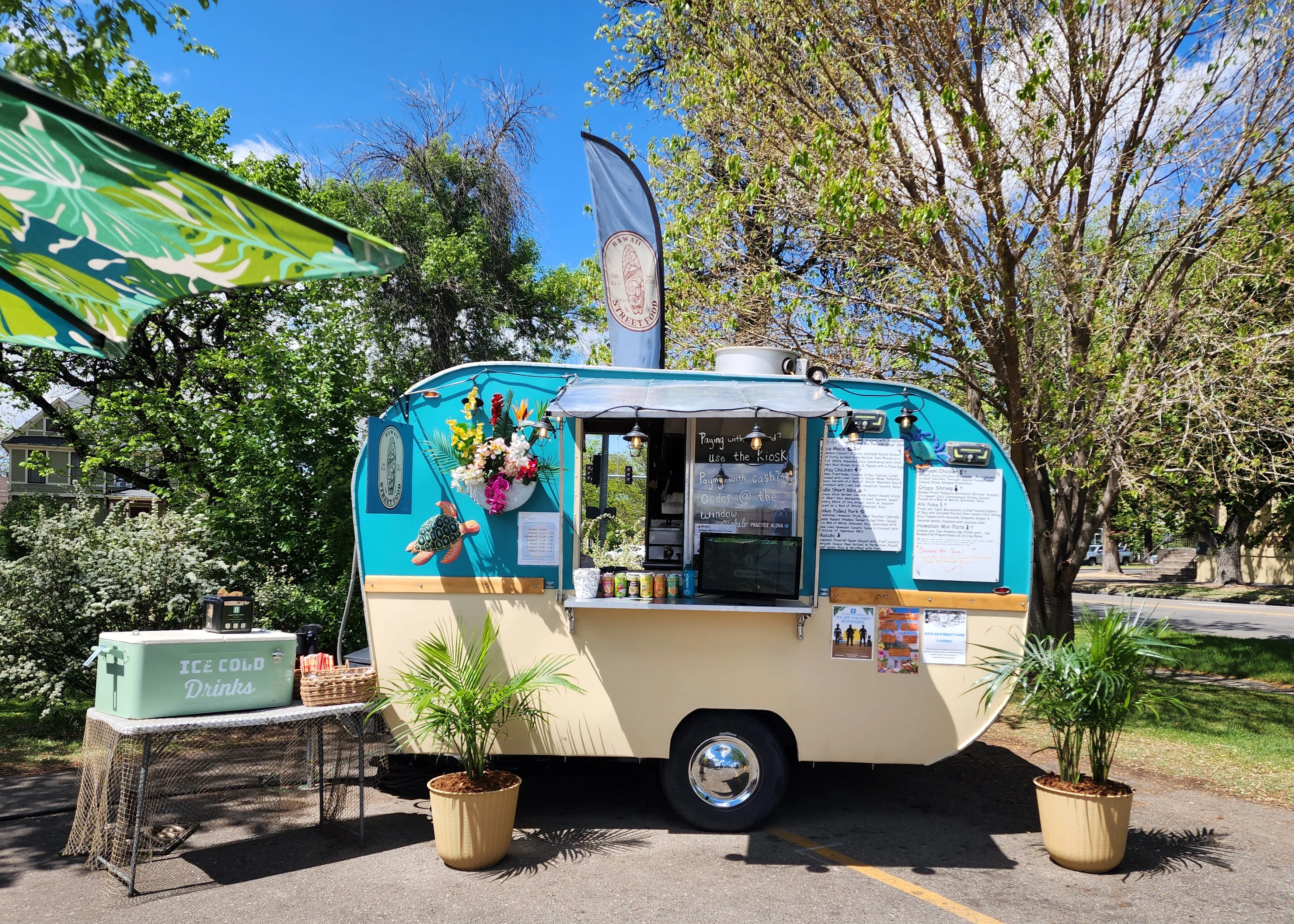 Food truck with vibrant graphics parked in an urban setting.