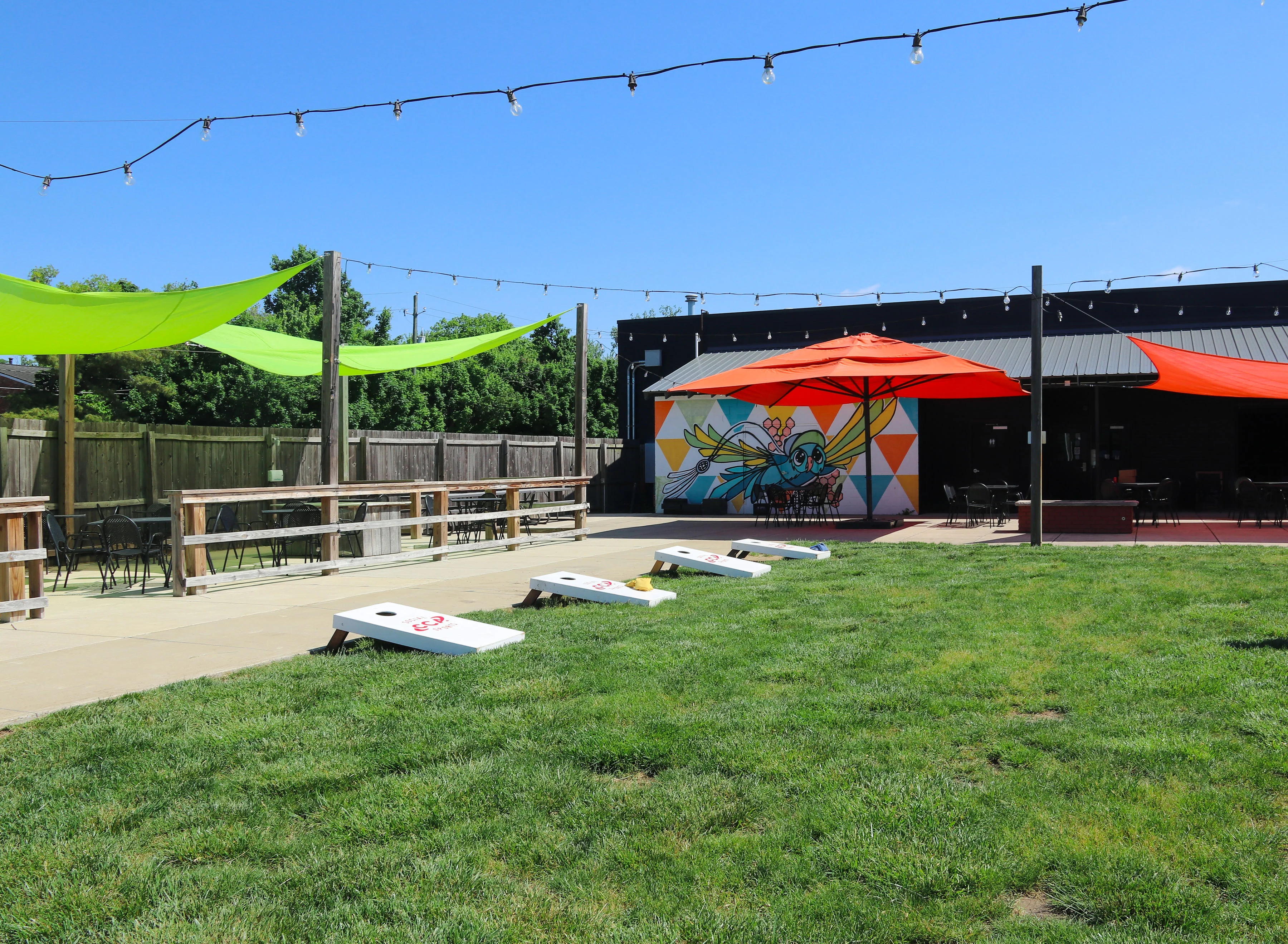 Outdoor dining area with colorful umbrellas and lawn games