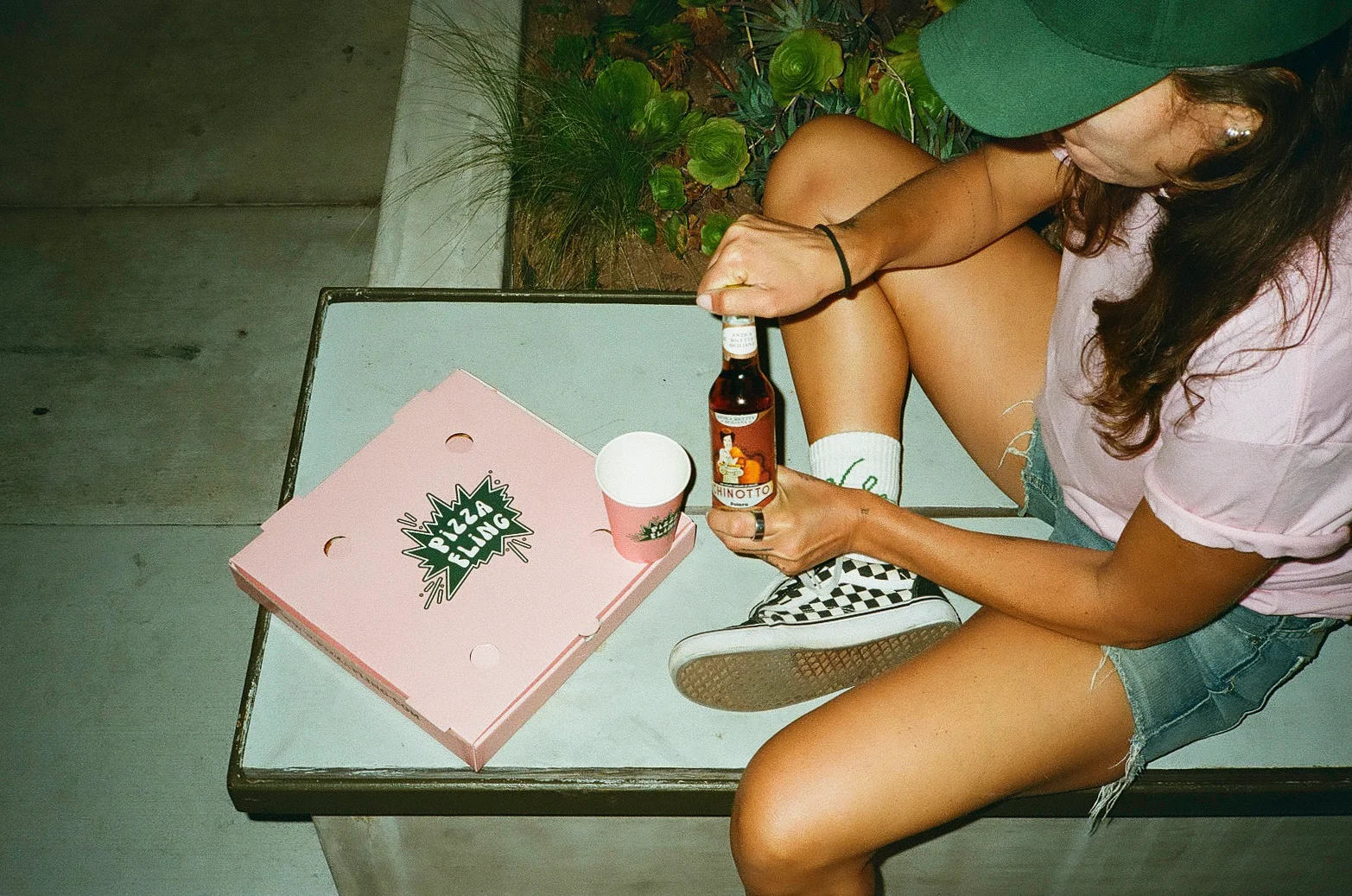 Chinotto soda and pizza box in a casual outdoor setting