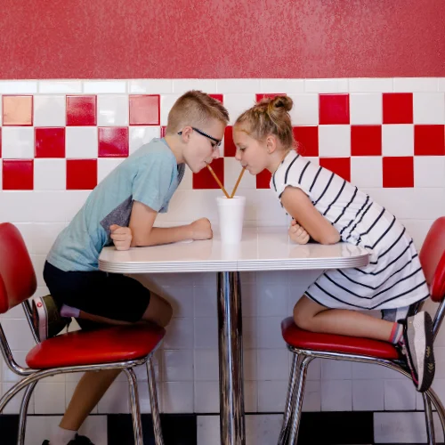 Kids sharing a milkshake at a retro diner