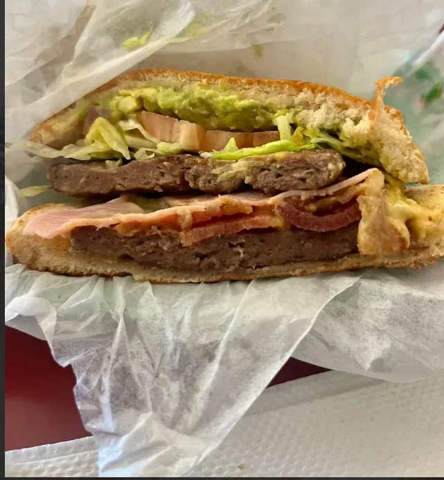 Delicious gourmet burger with fresh toppings on a wooden table