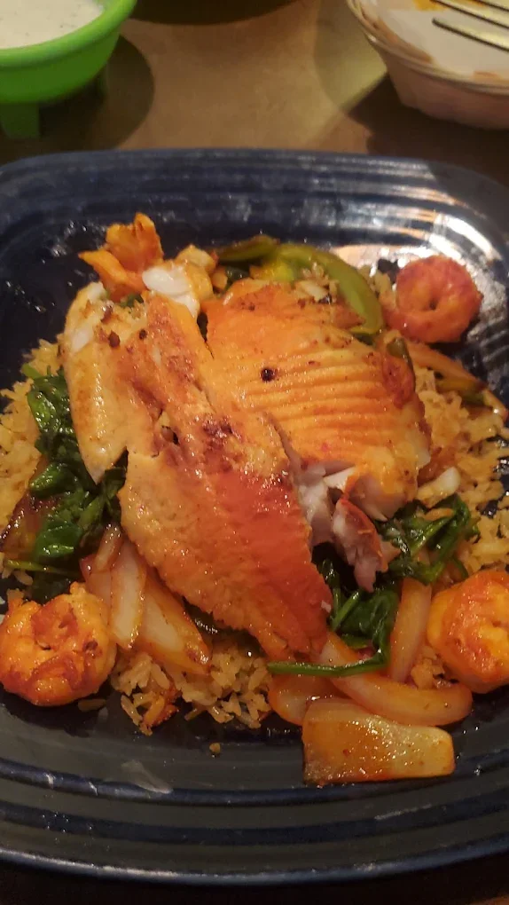 Crispy fried fish with shrimp and sautéed vegetables on rice