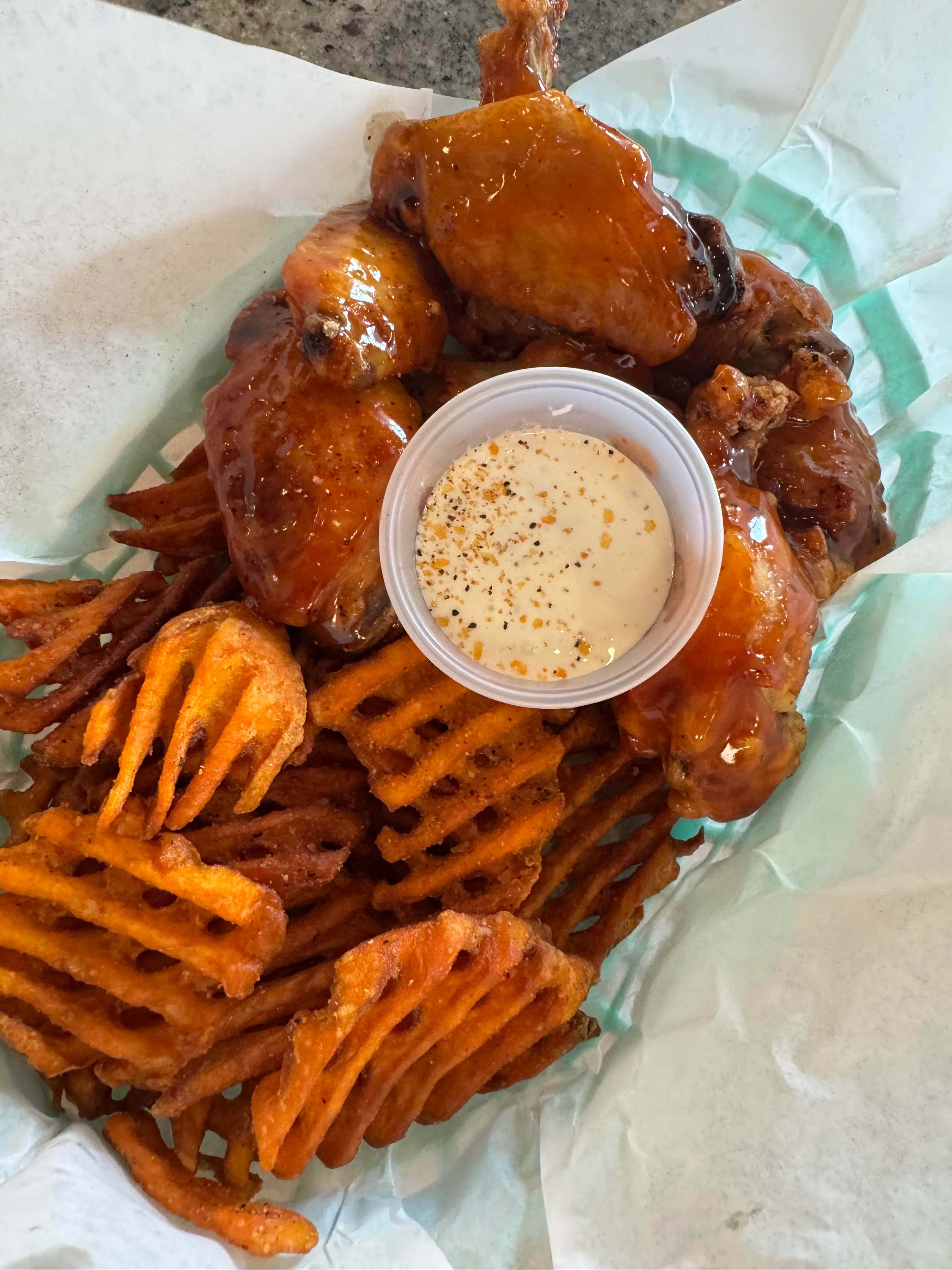 Crispy buffalo chicken wings with sweet potato fries