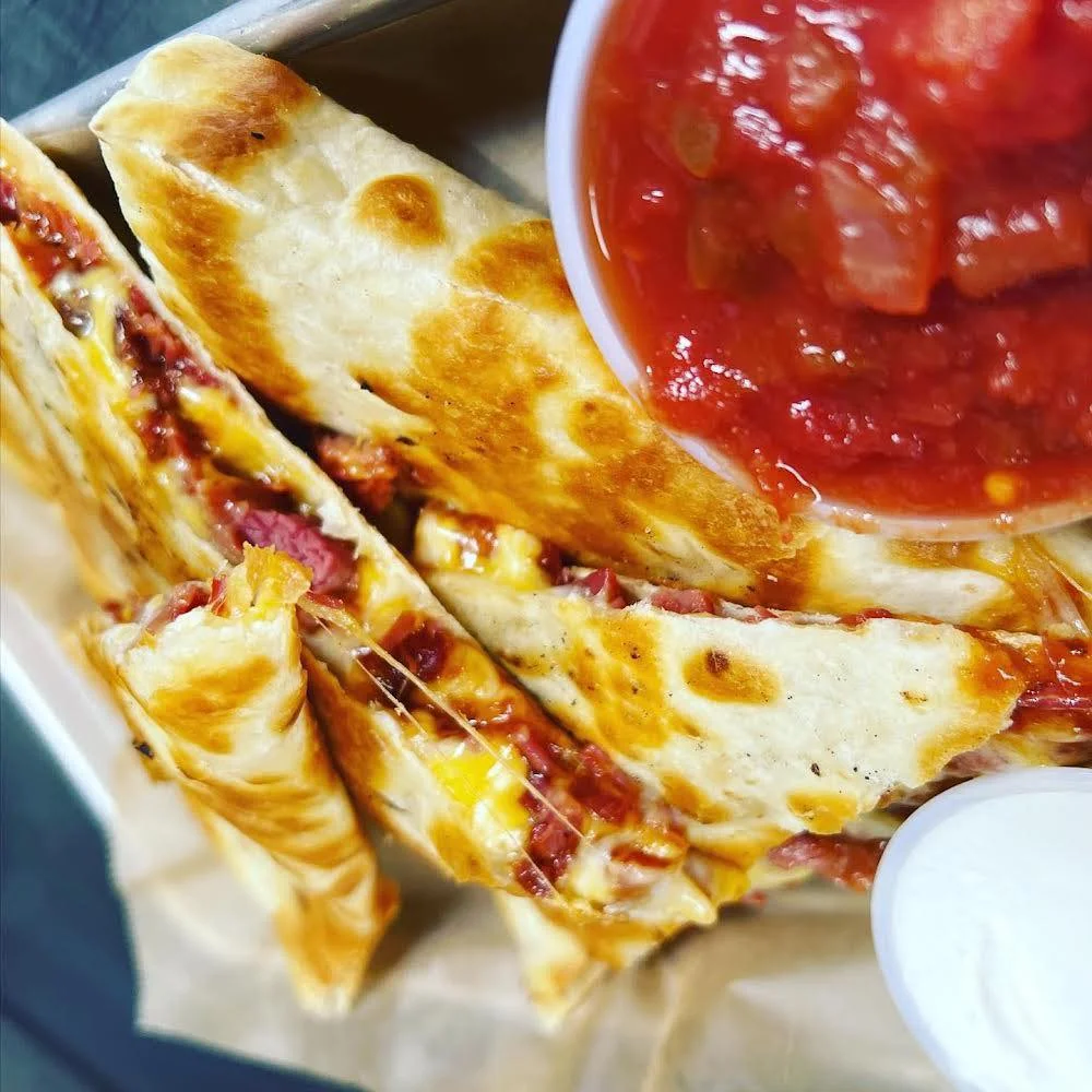 Cheesy quesadilla served with salsa and sour cream