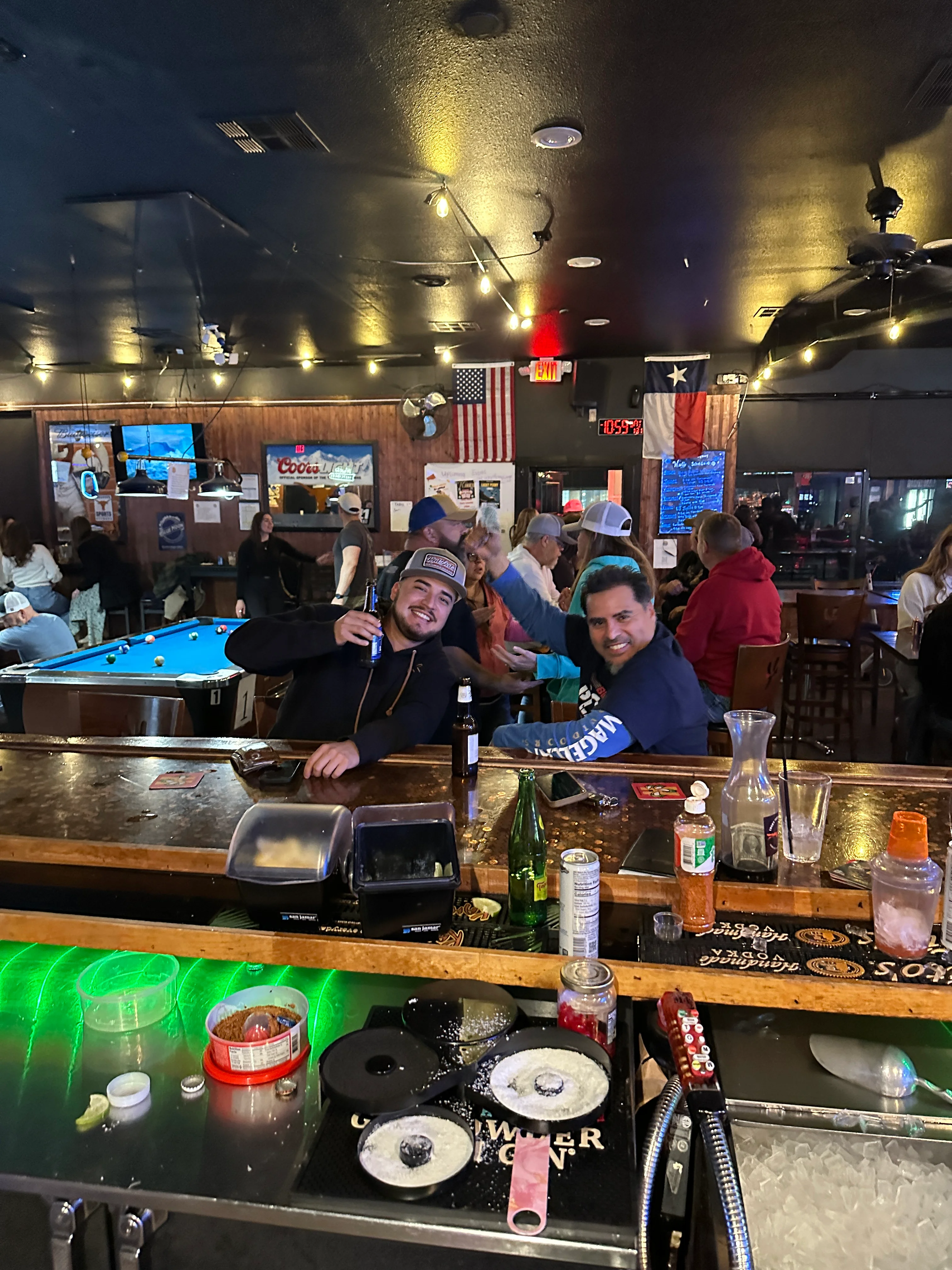 Lively bar scene with patrons enjoying drinks and playing pool