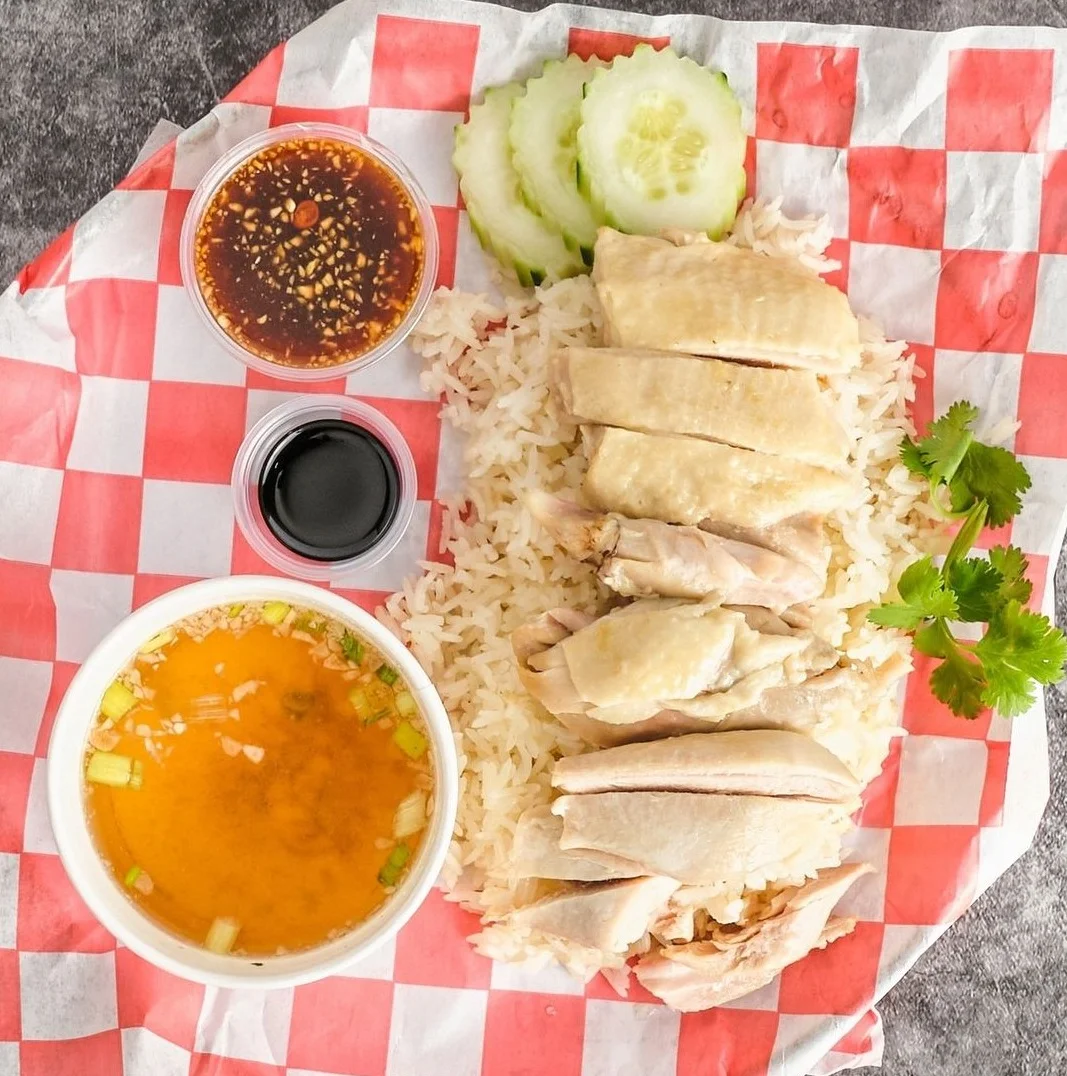 Hainanese chicken rice served with soup and sauces