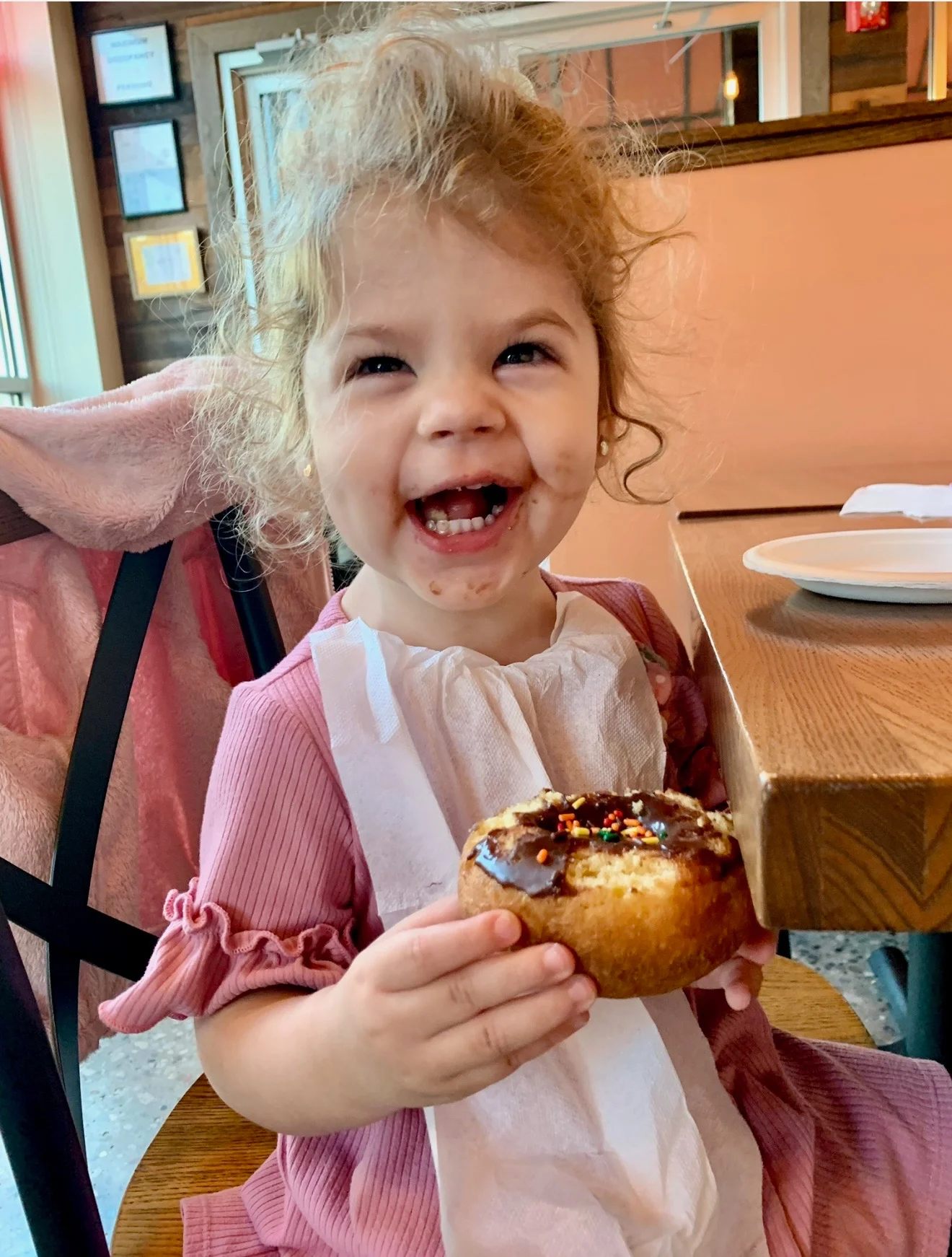 Happy child enjoying a chocolate frosted donut