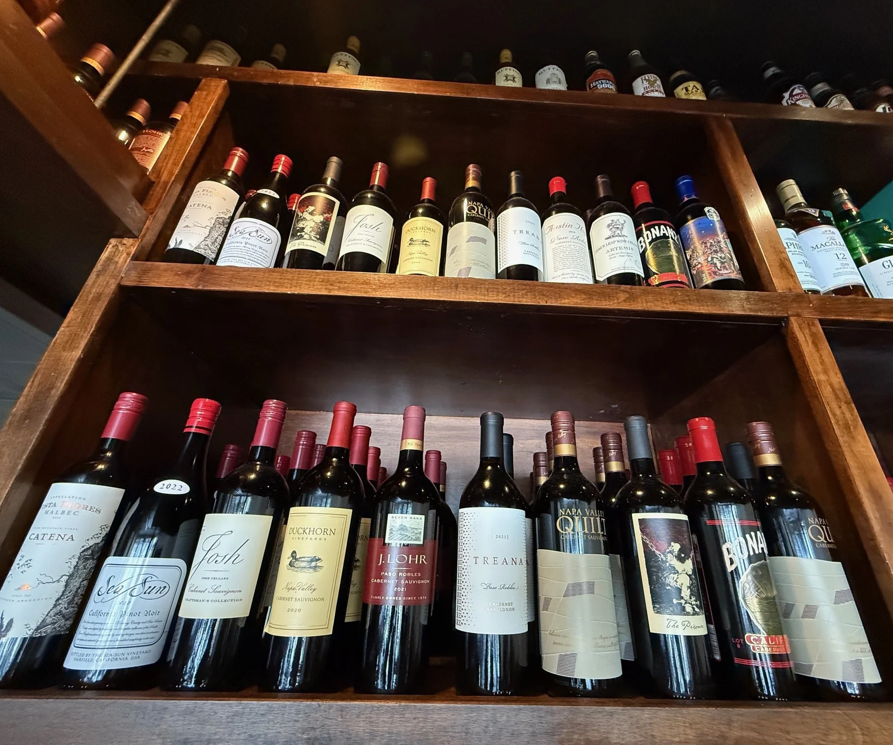 Wine selection displayed on wooden shelves in a cozy restaurant
