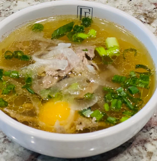 Bowl of Vietnamese pho with beef and fresh herbs