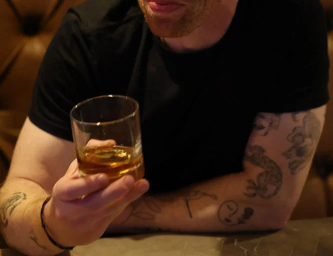Man enjoying a whiskey in a cozy restaurant setting