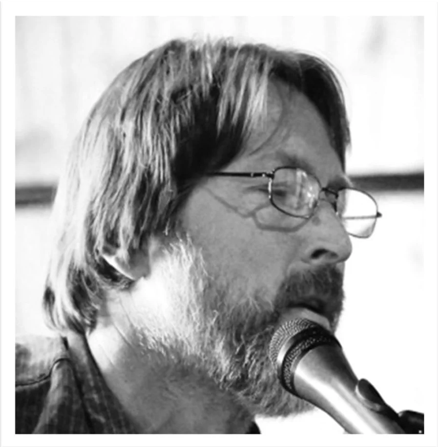 Musician singing into a microphone on stage