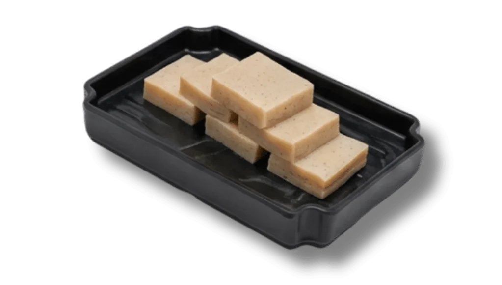 A black tray with stacked rectangular pieces of light-colored dessert.