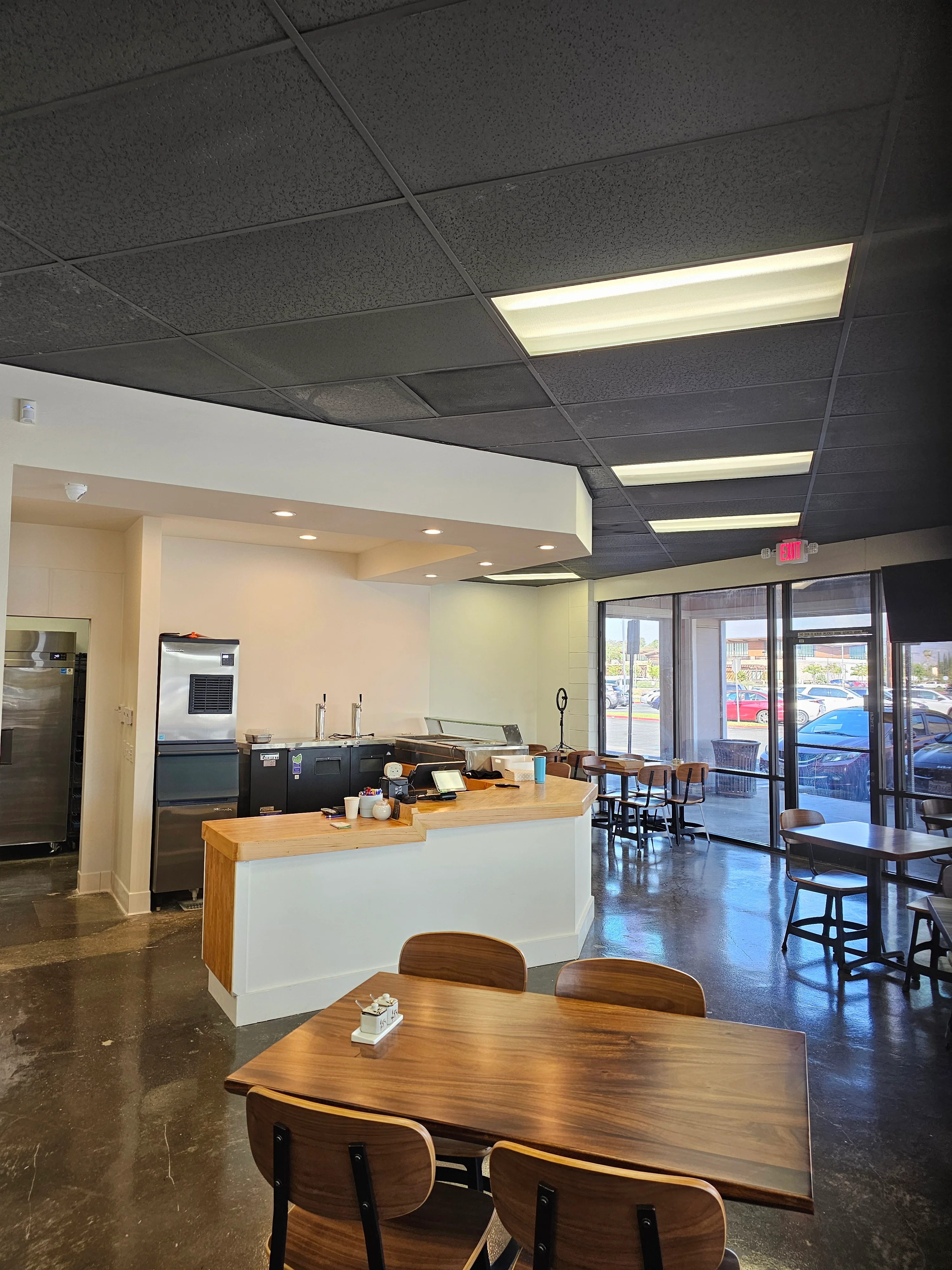 Modern restaurant interior with wooden tables and open kitchen