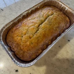 A small loaf in a foil tray, freshly baked and golden brown on top.