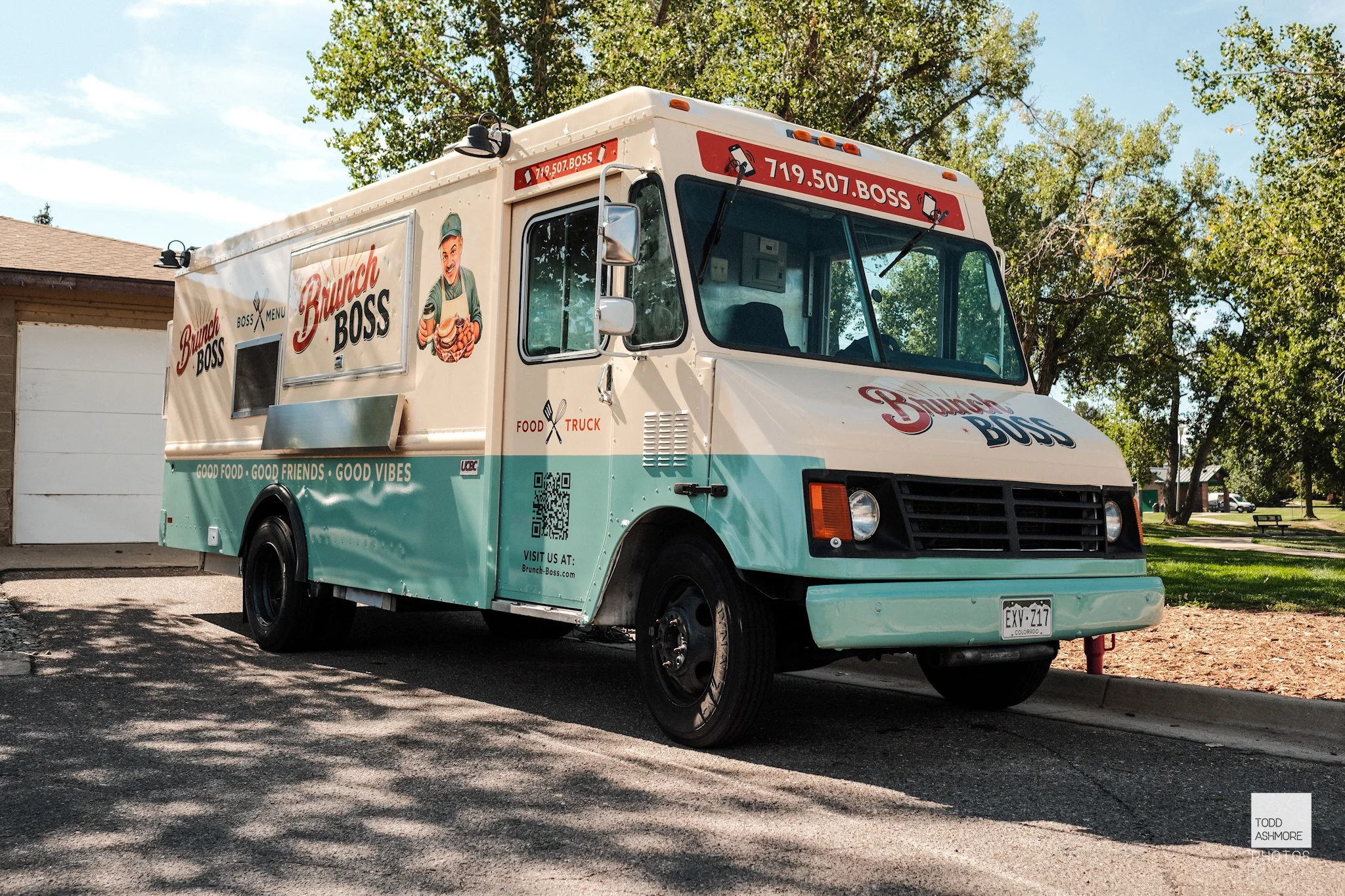 A food truck displaying the name 'Brunch Boss,' featuring a colorful design with a light cream and mint green color scheme. The front of the truck includes a phone number.
