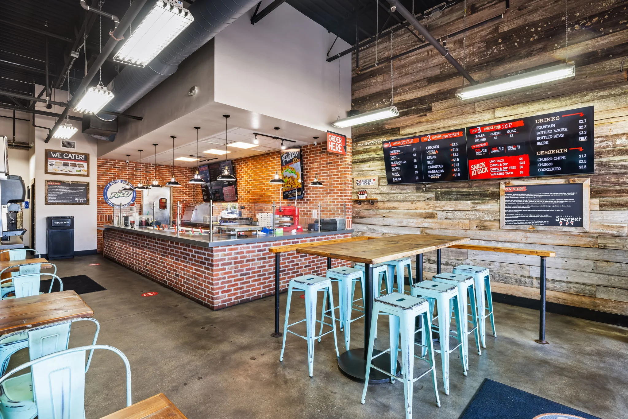 Interior of a burrito restaurant with a wooden table and colorful seating.