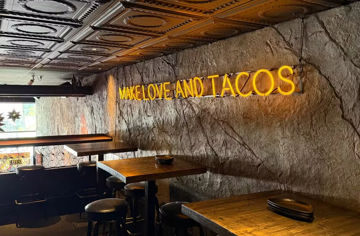 A lively dining area with artistic wall murals, vibrant decor, and patrons engaging in conversation.