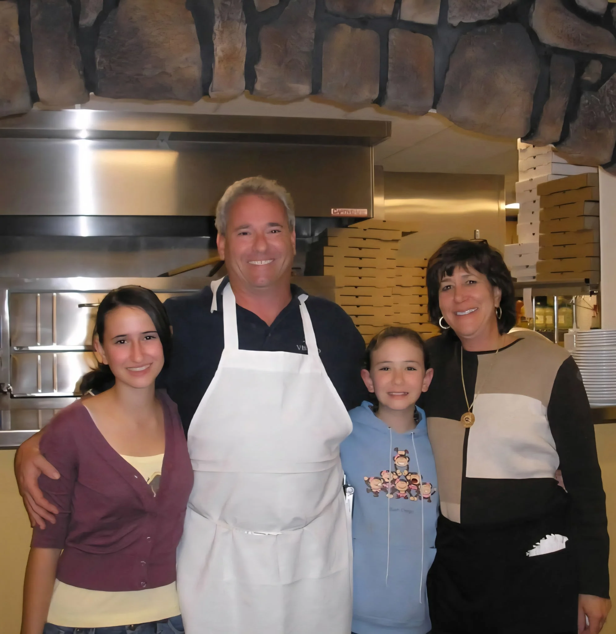 Family-owned restaurant team smiling in the kitchen