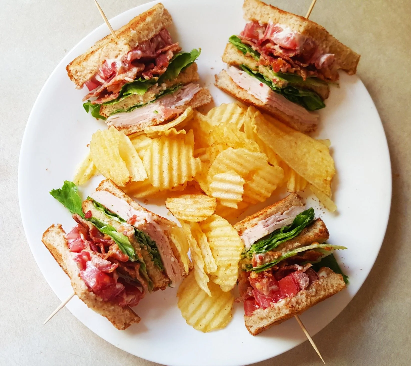 A delicious club sandwich with layers of turkey, bacon, lettuce, and tomato.